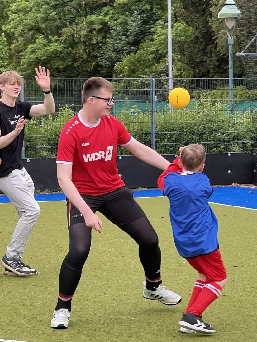Trainer und Kind spielen gemeinsam auf dem Hockeyfeld