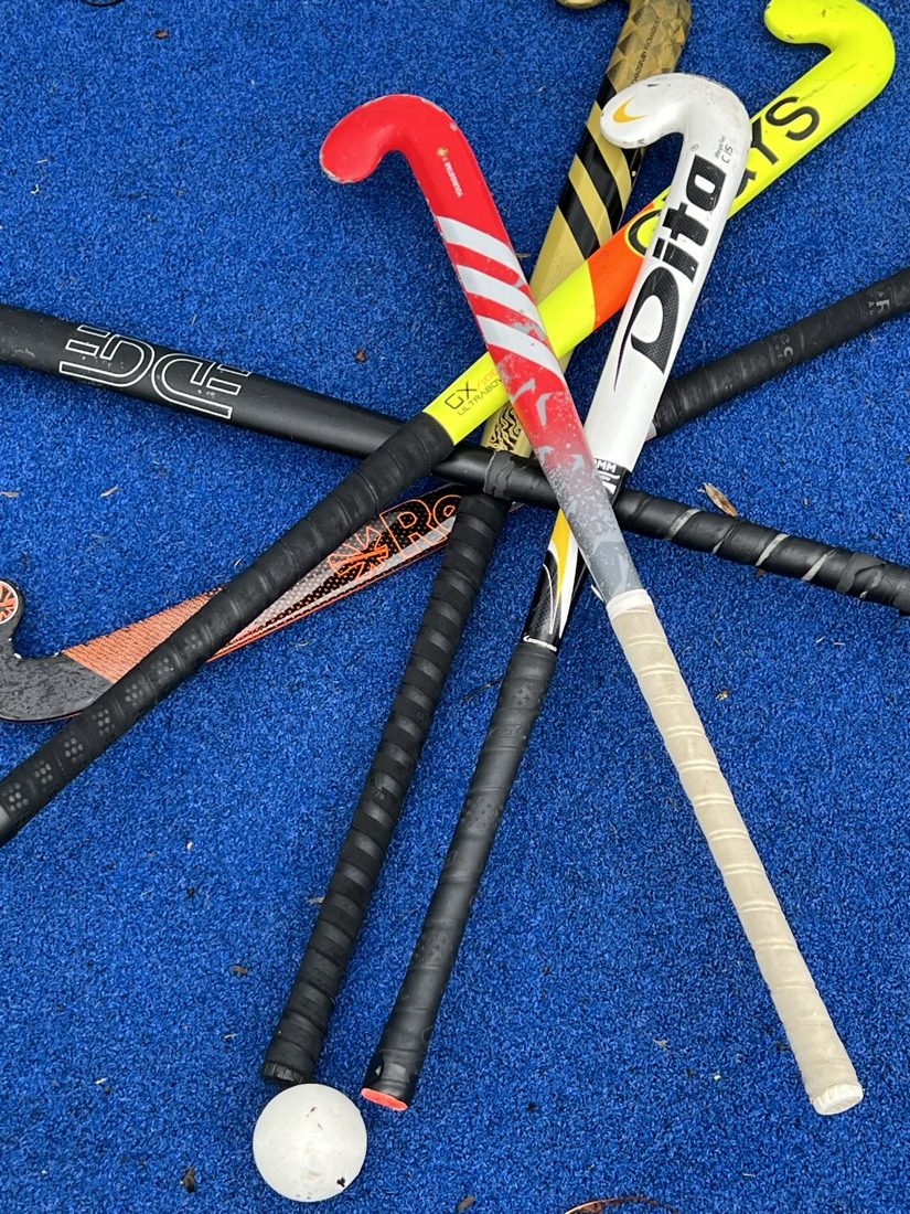 Hockeyschläger und Ball auf blauem Boden