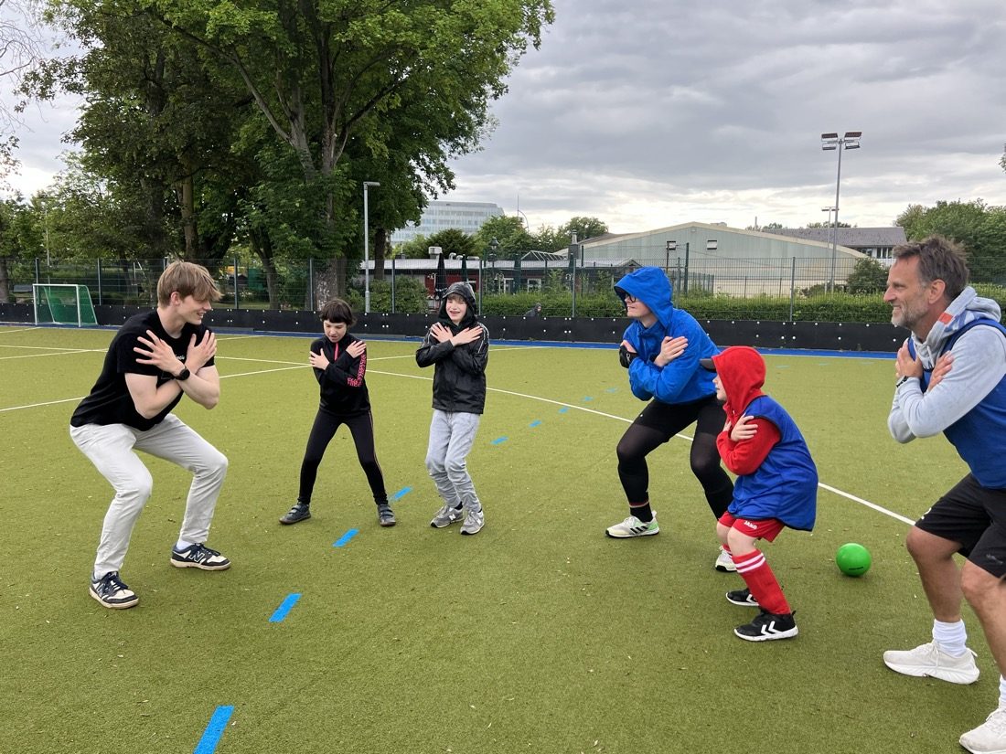 Kinder und Trainer mitten im Spiel auf dem Feld