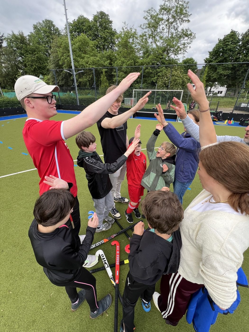 Team-Jubel: Kinder und Trainer strecken gemeinsam die Hände in die Mitte